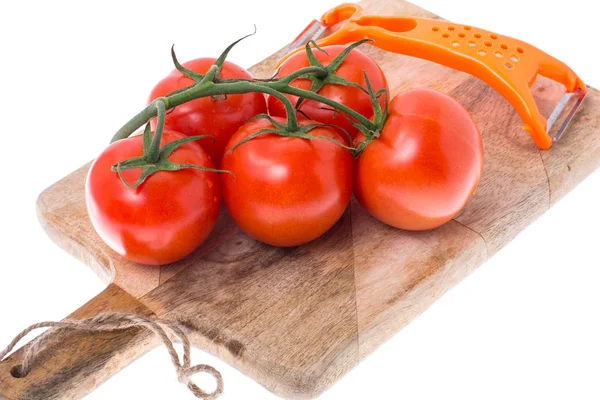 Red tomatoes on branch, knife for vegetables, wooden board — Stock Photo, Image