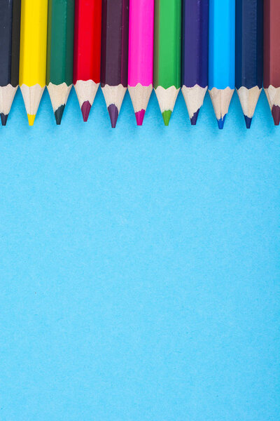 Канцелярские принадлежности: цветные карандаши на синем фоне
.
