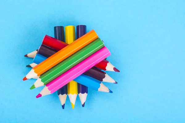 Канцелярские принадлежности: цветные карандаши на синем фоне . — стоковое фото