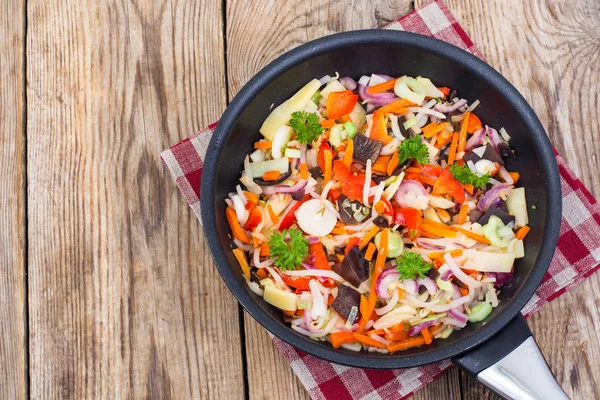 Gefrorene gekochte Gemüsemischung in Pfanne auf hölzernem Hintergrund, — Stockfoto