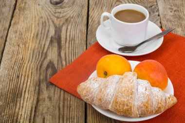 Kahvaltı. Taze kruvasan ve kahve süt üzerinde ahşap ile