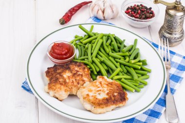 Yeşil fasulye ve pirzola Beyaz ahşap masa üzerinde öğle yemeği