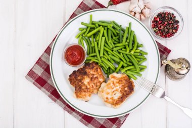 Yeşil fasulye ve pirzola Beyaz ahşap masa üzerinde öğle yemeği