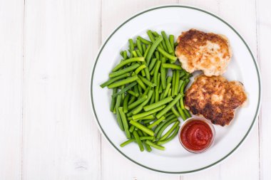 Yeşil fasulye ve pirzola Beyaz ahşap masa üzerinde öğle yemeği