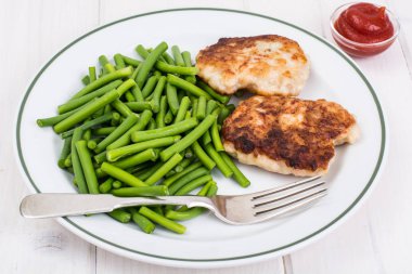 Yeşil fasulye ve pirzola Beyaz ahşap masa üzerinde öğle yemeği