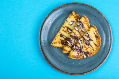 Pastel arka plan üzerinde çikolata tepesi ile tatlı krep