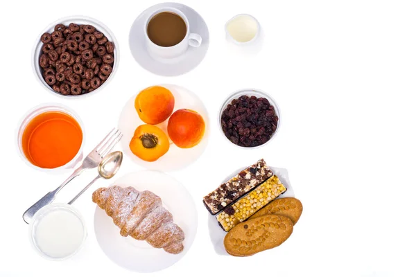 Ontbijttafel met croissant, muesli, melk, honing en fruit — Stockfoto