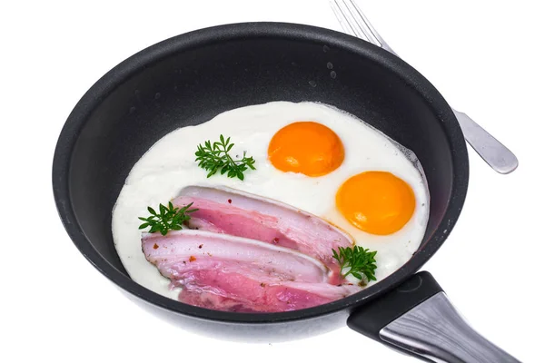 Fried eggs and bacon in frying pan on white background — Stock Photo, Image