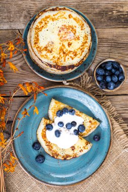 Ahşap masa üstüne bir yaban mersini ve sos ile Amerikan krep