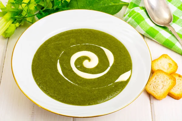 Beyaz ahşap masa üzerinde yeşil krem ıspanak çorbası