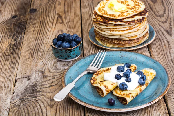 Ahşap masa üstüne bir yaban mersini ve sos ile Amerikan krep