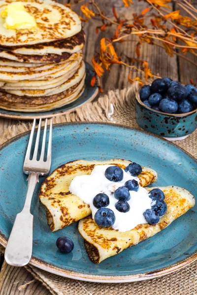 Ahşap masa üstüne bir yaban mersini ve sos ile Amerikan krep