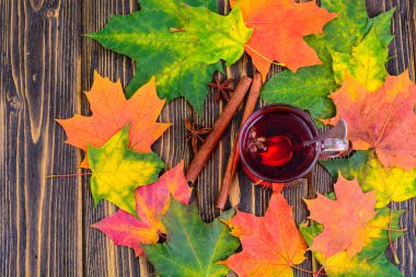 Kırmızı çay ile pembe ahşap masaya sonbahar yaprakları