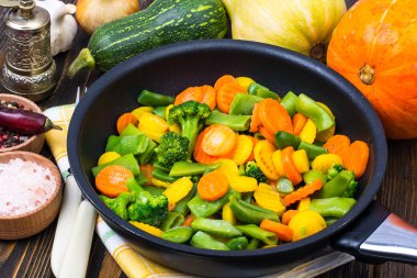 Yemekleri kızartma tavada karıştırın Dondurulmuş sebzeler