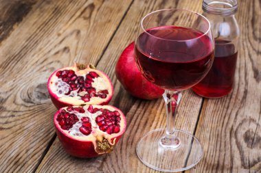 Ahşap masa üzerinde tam ve yarım kesimli nar