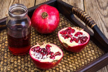 Ahşap masa üzerinde tam ve yarım kesimli nar