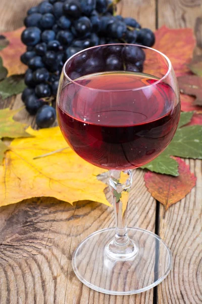 Composizione con calice di vino rosso e uva su tavola di legno primo piano — Foto Stock