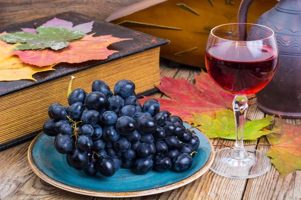 Natura morta retrò con vino rosso, libro, orologio e uva — Foto Stock