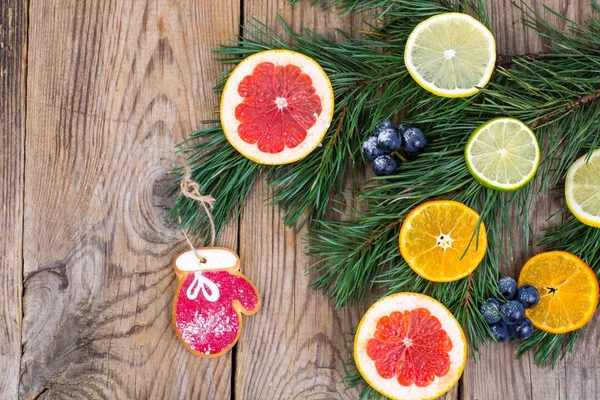 Домашнее пряничное печенье с глазурью и ветви рождественской елки с фруктами . — стоковое фото