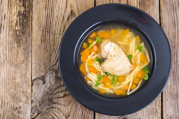 Sup dengan ayam, labu dan mie di atas meja kayu — Stok Foto