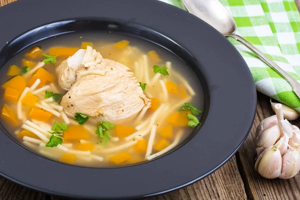 Soup with chicken, pumpkin and noodles on wooden table — Stock Photo, Image