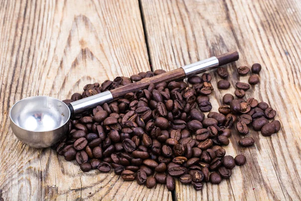 Bunch of coffee beans on wooden table — Stock Photo, Image