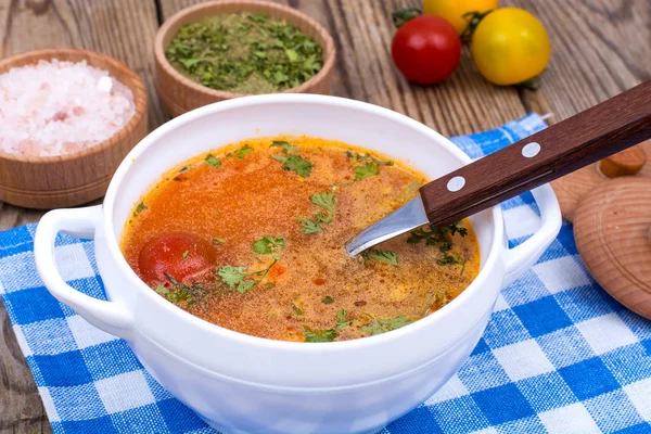 White bowl with hot vegetable soup on napkin