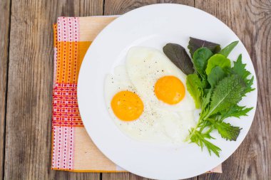 Kahvaltı. Taze salata yaprakları ve iki kızarmış yumurta