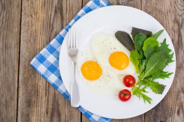 Kahvaltı. Taze salata yaprakları ve iki kızarmış yumurta