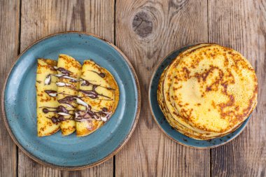 Ahşap masa günü kahvaltıda çikolata soslu krep dolması