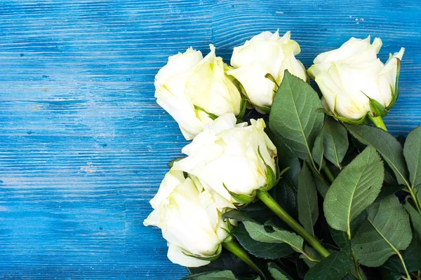 青い木製の背景に新鮮な白バラ — ストック写真