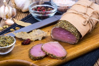 Sarımsak ve baharat ahşap arka plan üzerinde jambon füme parçası. Rustik tarzı