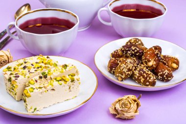 Oryantal tatlılar-helva ve parlak pembe bir arka plan üzerinde tarihleri