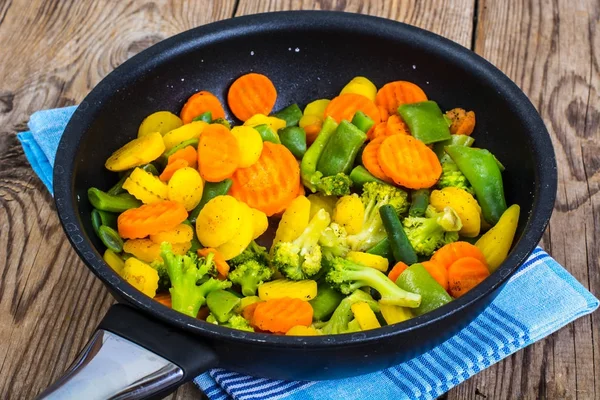 Morötter röda och gula, broccoli, bönor i stekpanna — Stockfoto