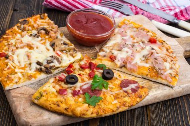 Üç parça bir tahta üzerinde farklı pizza