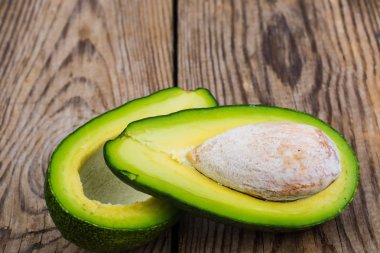 Taze bütün avokado ve yarım ahşap tablo