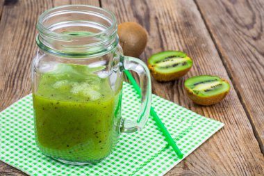 Yeşil güler yüzlü lezzetli cam ve ahşap masa üzerinde taze kivi