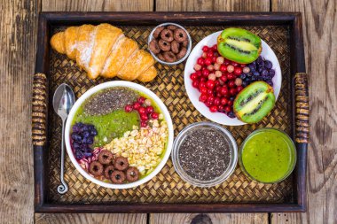 Meyve yemekleri ve öğle yemeği için kruvasan ile ahşap tepsi