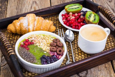 Meyve yemekleri ve öğle yemeği için kruvasan ile ahşap tepsi