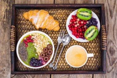 Meyve yemekleri ve öğle yemeği için kruvasan ile ahşap tepsi