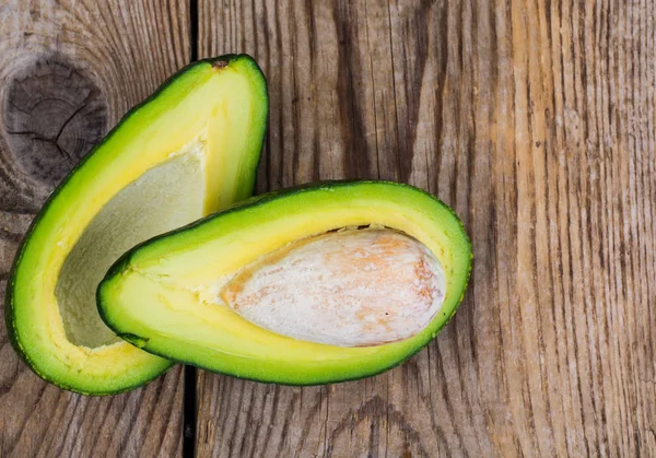 Taze bütün avokado ve yarım ahşap tablo