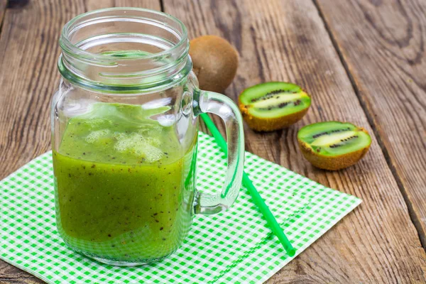 Yeşil güler yüzlü lezzetli cam ve ahşap masa üzerinde taze kivi