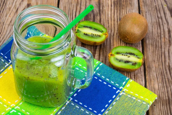 Yeşil güler yüzlü lezzetli cam ve ahşap masa üzerinde taze kivi