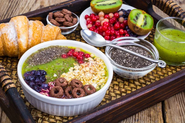 Meyve yemekleri ve öğle yemeği için kruvasan ile ahşap tepsi