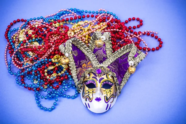 Festival Mardi Gras mask and multicolored beads on bright background — Stock Photo, Image
