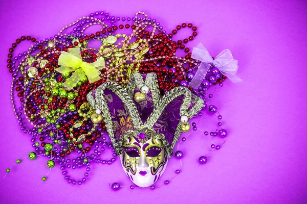 Festival Mardi Gras mask and multicolored beads on bright background — Stock Photo, Image