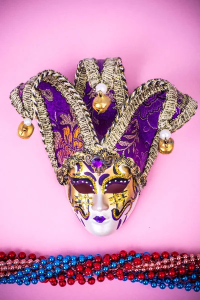 Festival Mardi Gras mask and multicolored beads on bright background — Stock Photo, Image