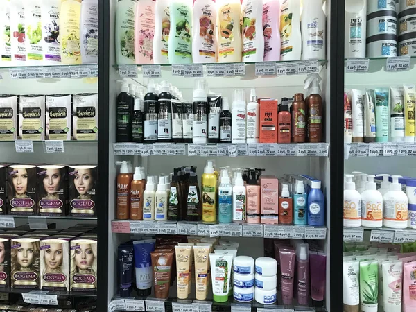 髪化粧品異なった製造業者からのスーパー マーケットのショーケースをミンスク、ベラルーシ - 2018 年 1 月 13 日:: シャンプー、マスク、スクラブ、塗料、kondionion、髪のためのクリーム. — ストック写真