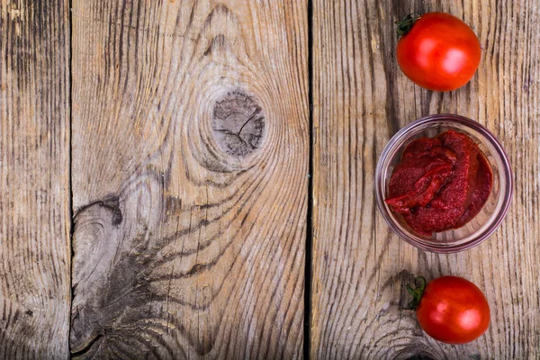Tomato paste, ketchup, cherry tomatoes on wooden table
