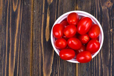 Ahşap masa, üstten görünüm ıslak zeminde küçük kırmızı olgun domates